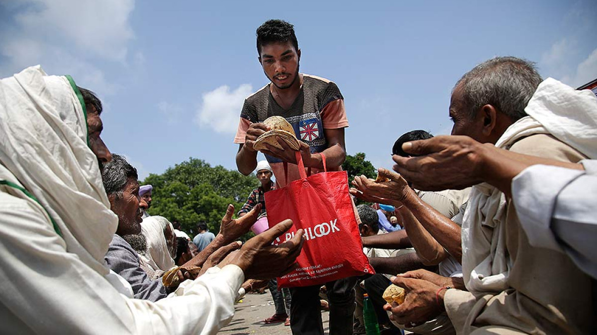 A volunteer distributes rotis among supporters of the Dera Sacha Sauda sect