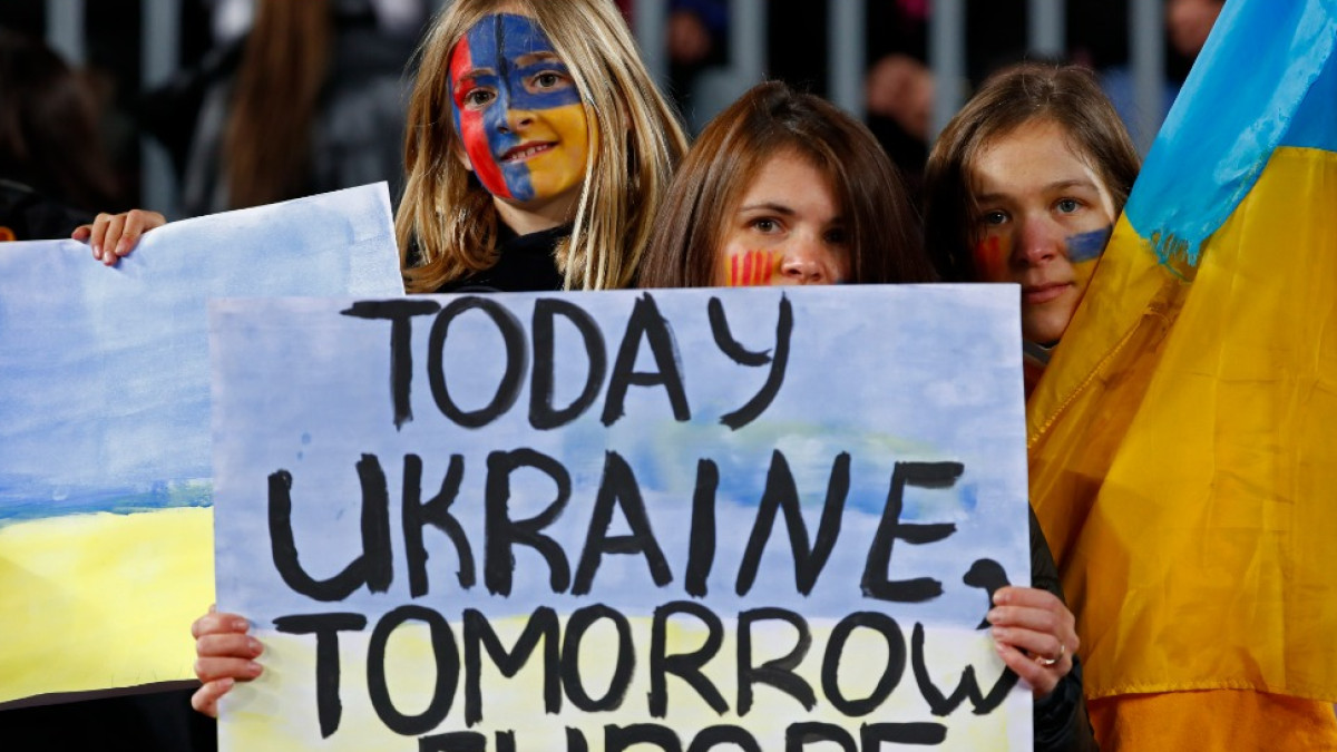 Two Barcelona supporters hold a sign in support of Ukraine during a La Liga 2021-22 match. Two Barcelona supporters hold a sign in support of Ukraine during a La Liga 2021-22 match.